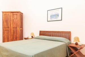 una camera con letto e armadio in legno di Bilocale Garibaldi nel centro di Talamone a Talamone