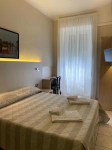 ein Schlafzimmer mit einem Bett mit zwei Handtüchern darauf in der Unterkunft Hotel Due Giardini in Mailand