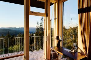 ein Zimmer mit einem großen Fenster und einem Holztisch in der Unterkunft Lysebu Hotel in Oslo + 52 Fotos