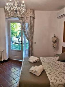 1 dormitorio con 2 toallas en una cama con lámpara de araña en Il Torrione, en Castiglione del Lago