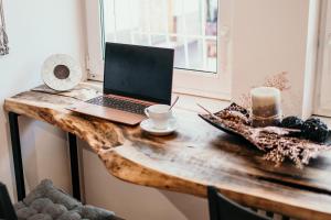 - un ordinateur portable sur une table en bois avec une tasse de café dans l'établissement Bascarsija Corner, à Sarajevo