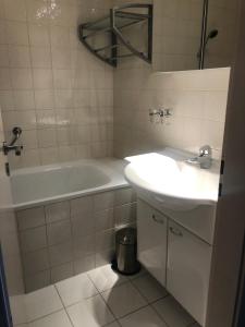 Baño blanco con bañera y lavamanos en Sunny Swiss apartment 6P near Télécabine by Jolidi, en Nendaz