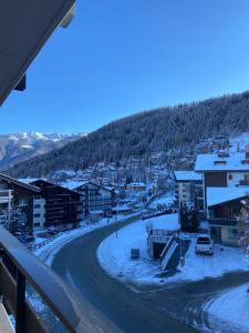 a view from a balcony of a town in the snow at Clair Vue A3 near Télécabine by Jolidi in Nendaz