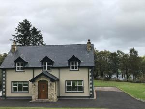 una casa blanca con techo negro en Loughview House, en Donegal