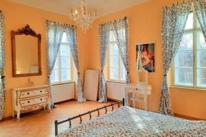 a bedroom with a bed and a mirror and windows at Sisi-Schloss Rudolfsvilla - Duo in Reichenau