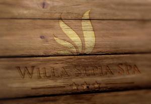 una mesa de madera con una mariposa grabada en ella en Willa Sepia SPA, en Wisła