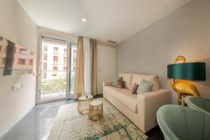 een woonkamer met een bank en een groot raam bij Holihome Rambla 24 in Alicante