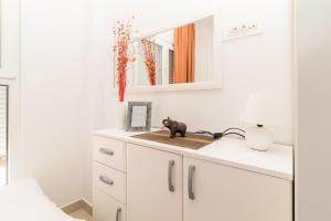 ein Badezimmer mit weißen Schränken und einem Spiegel in der Unterkunft Apartment Mini Condo Meljine in Herceg-Novi
