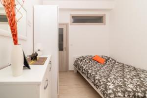 ein kleines Schlafzimmer mit einem Bett und einem Schreibtisch in der Unterkunft Apartment Mini Condo Meljine in Herceg-Novi