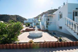 un patio con una fuente frente a un edificio en Iris Studios, en Karpathos