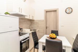 Una cocina con una mesa con un bol de fruta encima. en Apartment Mini Condo Meljine, en Herceg-Novi