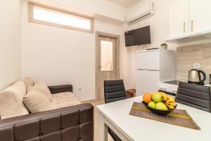- une cuisine et un salon avec un canapé et une corbeille de fruits dans l'établissement Apartment Mini Condo Meljine, à Herceg-Novi