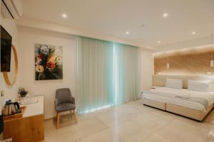 a bedroom with a bed and a chair and a window at Hai Hotel in Larnaca