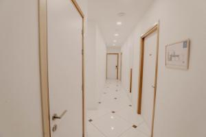 a hallway with a glass door and a tile floor at Hai Hotel in Larnaca