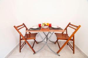 una mesa con dos sillas y un bol de fruta en ella en Iris Studios, en Karpathos