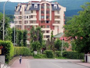 um homem a andar numa rua em frente a um grande edifício em Sunny apartment in the city Center em Truskavets