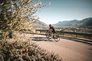 Un homme à vélo sur une route dans l'établissement Hotel Salgart, à Merano
