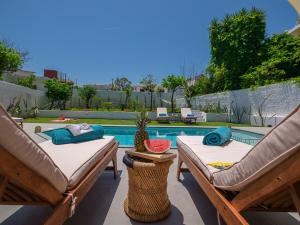 two lounge chairs and a pool in a backyard at Villa Belle Helene Kalamaki Chania in Kalamaki Chanion