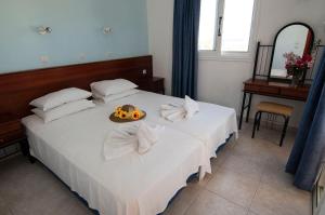 a bedroom with a bed with a bowl of food on it at Iris Studios in Karpathos