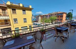un patio con mesas y sillas en el balcón en Hotel Sorriso, en Brenzone sul Garda