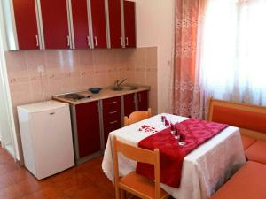 a small kitchen with a table with a red table cloth at Apartments Igalo Montenegro in Igalo