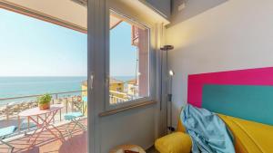 a room with a window and a view of the ocean at Babyaccommodation Family Panoramic I in Pietra Ligure