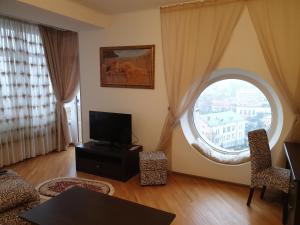 un soggiorno con una grande finestra e una TV di Sunny apartment in the city Center a Truskavec'