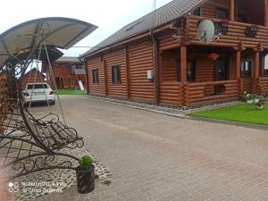 a wooden cabin with a bench in front of it at Woodhouse Svitiaz in Svityazʼ
