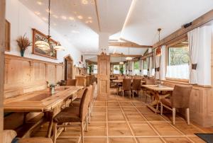 a restaurant with wooden tables and chairs at Hotel Gleimingerhof - Reiteralm in Gleiming