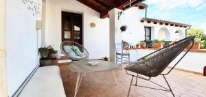 a patio with two chairs and a table on a porch at A casa di Anna in Galtellì +23 photos