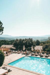 uma piscina com espreguiçadeiras ao lado de um resort em Mas des Herbes Blanches Hôtel & Spa – Relais & Châteaux em Joucas