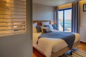 1 dormitorio con cama y ventana grande en Hotel Restaurant Les Venetes en Arradon