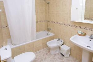 ein Badezimmer mit einem WC, einem Waschbecken und einer Badewanne in der Unterkunft HOTEL DON FELIPE in Carboneras