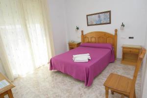 a bedroom with a purple bed with two towels on it at HOTEL DON FELIPE in Carboneras