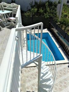 a white railing next to a pool with a slide at Apartman Stipić 2 in Kaštela