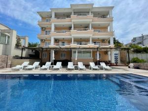 a hotel with a swimming pool in front of a building at Queen Kodre Apartments in Ulcinj