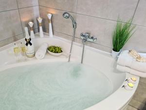 a bath tub filled with water in a bathroom at Strandhaus Rügen - Sauna, Kamin, Whirlpool in Baabe