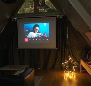 TV de pantalla plana en una habitación con luces de Navidad en Gîte piscine jacuzzi privatisés Clos Valentin, en Freulleville