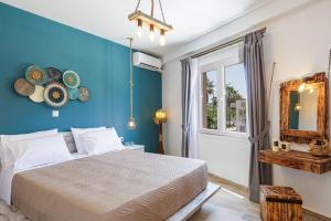 a bedroom with a bed and a blue wall at Semiso Beach Suites in Kournás