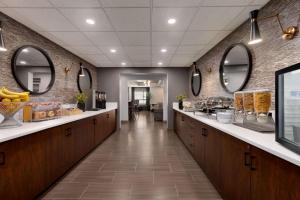 uma cafetaria com um longo corredor com lavatórios e espelhos em Microtel Inn & Suites by Wyndham Estevan em Estevan