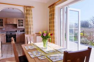 a kitchen with a table with a vase of flowers on it at TIRNANT- 3 Bed - GROUND FLOOR ROOMS -DOG FRIENDLY in Trearddur