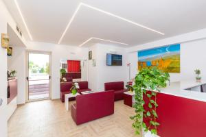 a living room with red chairs and a table at Dipladenia Garden Country Resort in Mascali