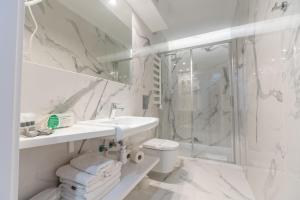 biała łazienka z umywalką i prysznicem w obiekcie Villa Bravo & SPA w mieście Międzyzdroje +37 zdjęć
