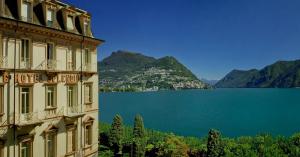 un edificio con vista sul lago e sulle montagne di Hotel Splendide Royal a Lugano