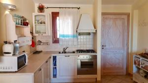 a kitchen with a sink and a stove top oven at Fiordaliso Aurora in Olbia