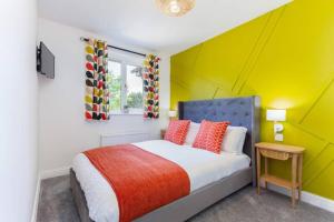 a bedroom with a bed with a yellow wall at Avella by the Park in Lytham St Annes