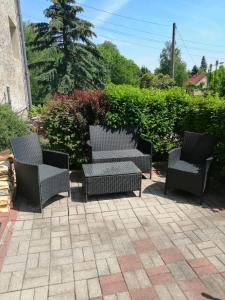 three wicker chairs and a table on a patio at Ferienwohnung Kleine Seite 16 in Görlitz