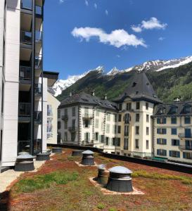 un groupe de bâtiments avec des montagnes en arrière-plan dans l'établissement Ladybird Inn, à Chamonix-Mont-Blanc