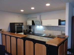 een keuken met witte kasten en een aanrechtblad bij Ferienhaus Domus in Xanten +28 foto's