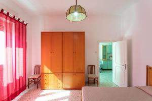 ein Schlafzimmer mit einem Schrank und einem roten Vorhang in der Unterkunft Appartamento Giovanna a 50m dal mare in Marina di Mancaversa